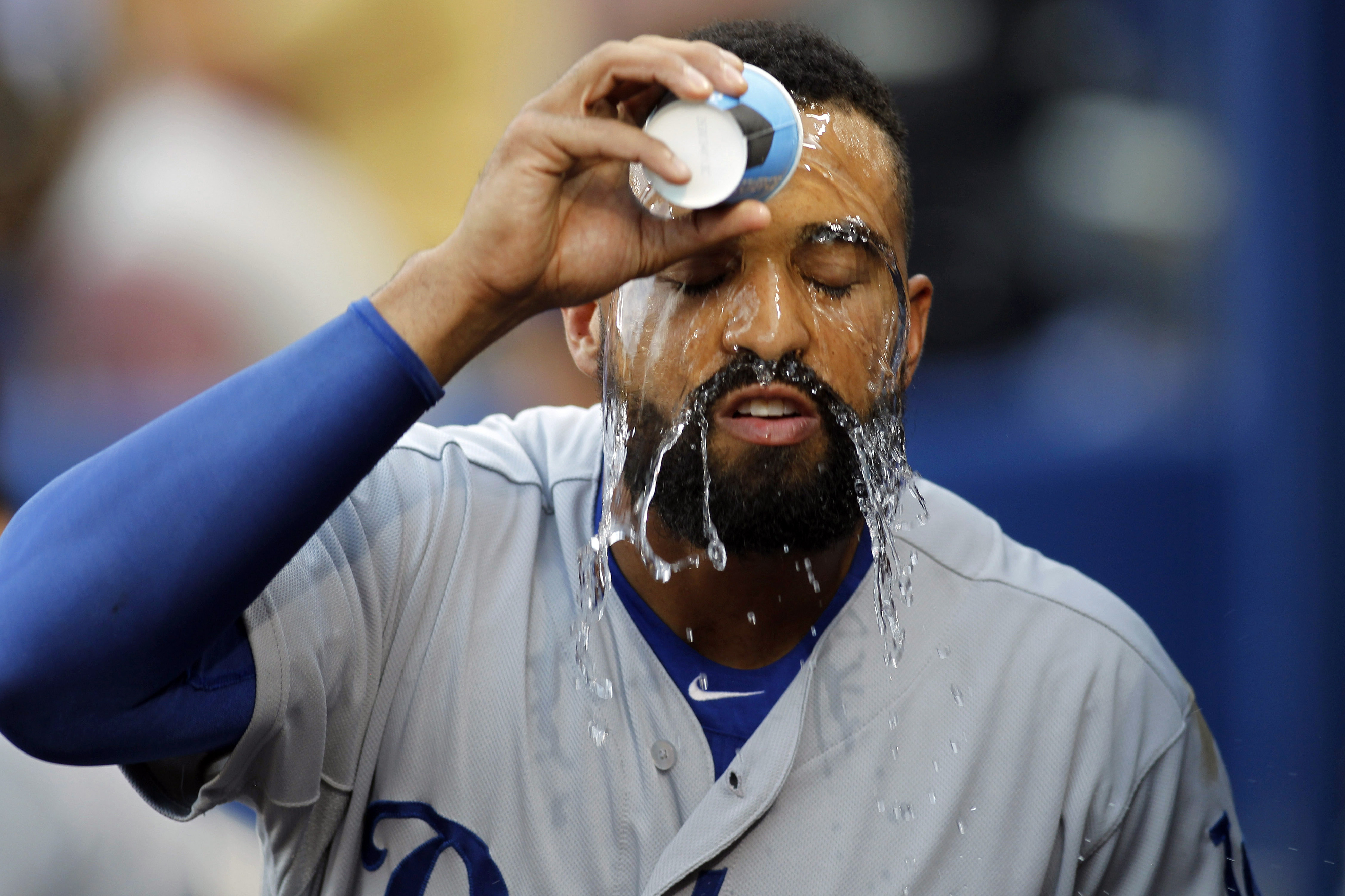 Aug 12, 2014; Atlanta, GA, USA; Los Angeles Dodgers left fielder Matt Kemp (27) pours water on his face against the Atlanta Braves in the second inning at Turner Field. Mandatory Credit: Brett Davis-USA TODAY Sports